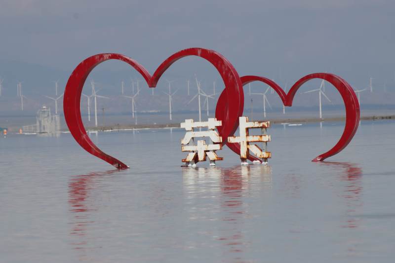 茶卡盐湖心形雕塑与风车图片