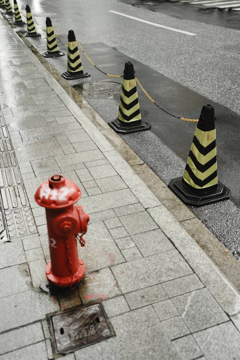 雨中路边的消防栓与锥形标图片