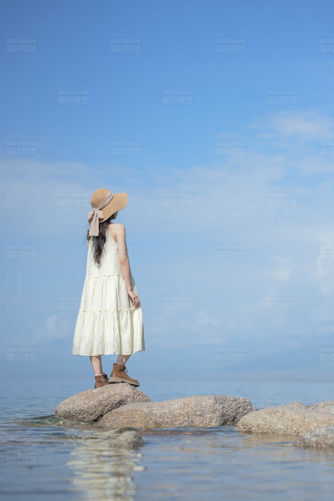 海边岩石上的女孩图片