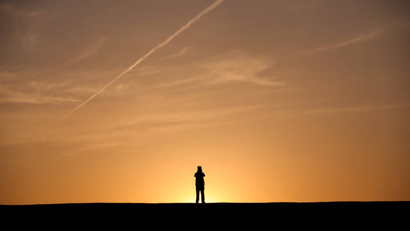 日落时分地平线上的孤独身影图片