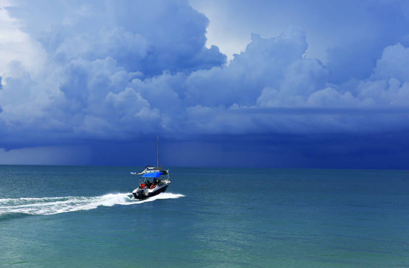 疾驰在阴云密布海面上的快艇图片