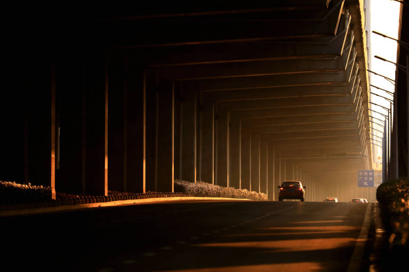 夕阳余晖洒在城市高架桥立柱上图片
