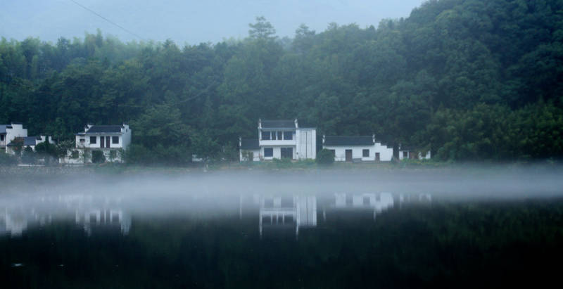 皖南晨雾中的湖畔村庄图片