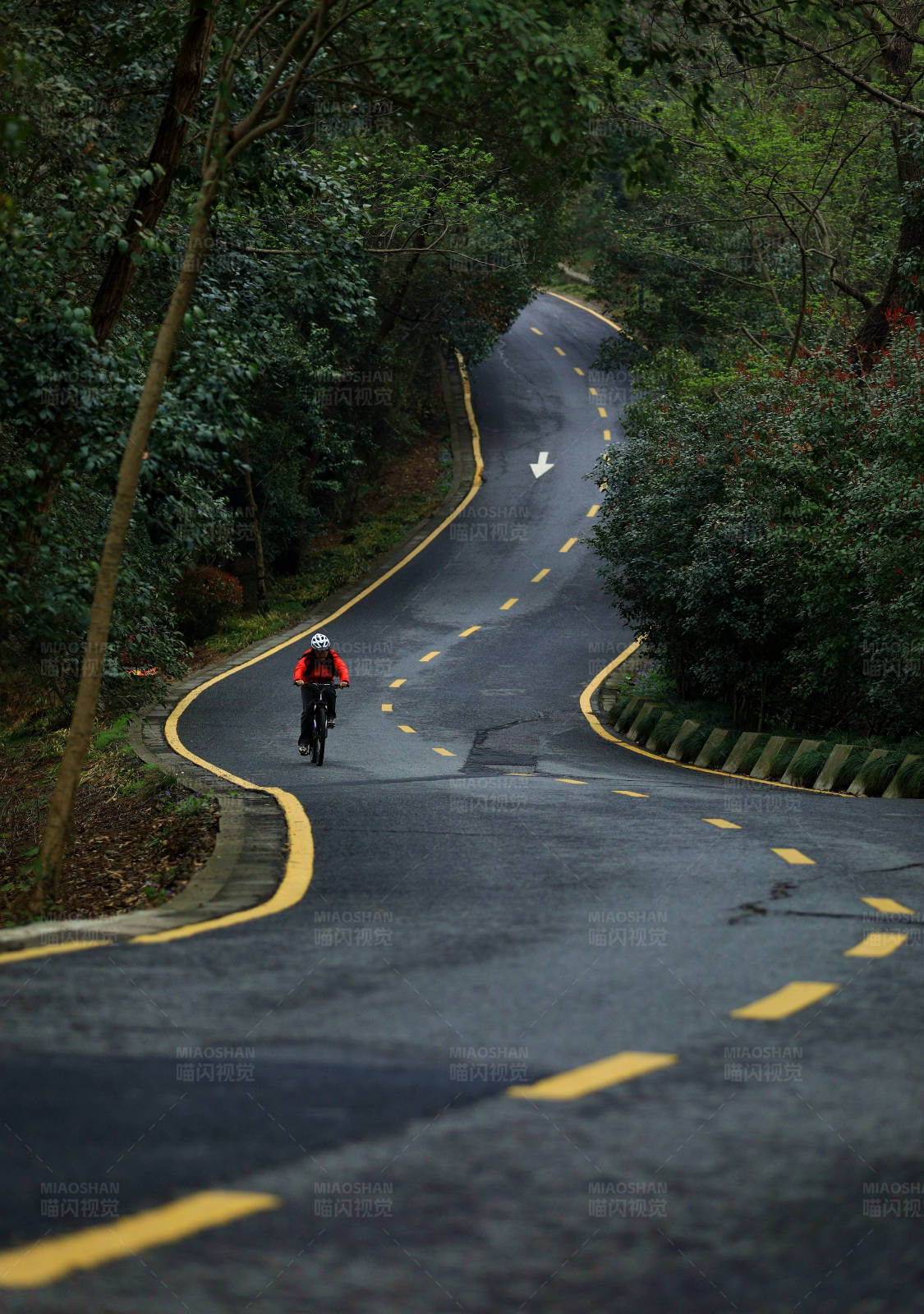 蜿蜒山路上孤独的骑行者图片