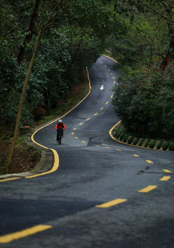 蜿蜒山路上孤独的骑行者图片