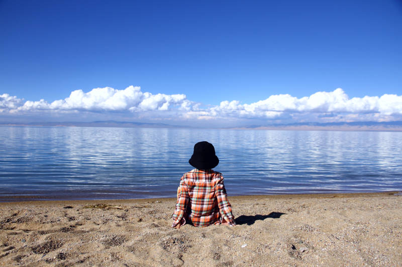 青海湖畔独坐的儿童图片