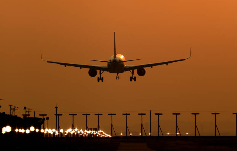 夕阳下的飞机降落图片