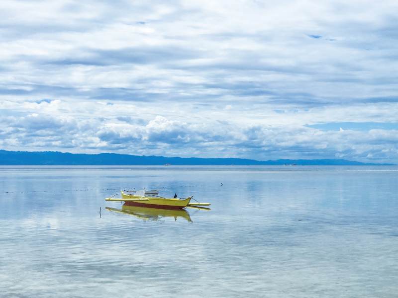 孤舟漂浮宁静海面图片