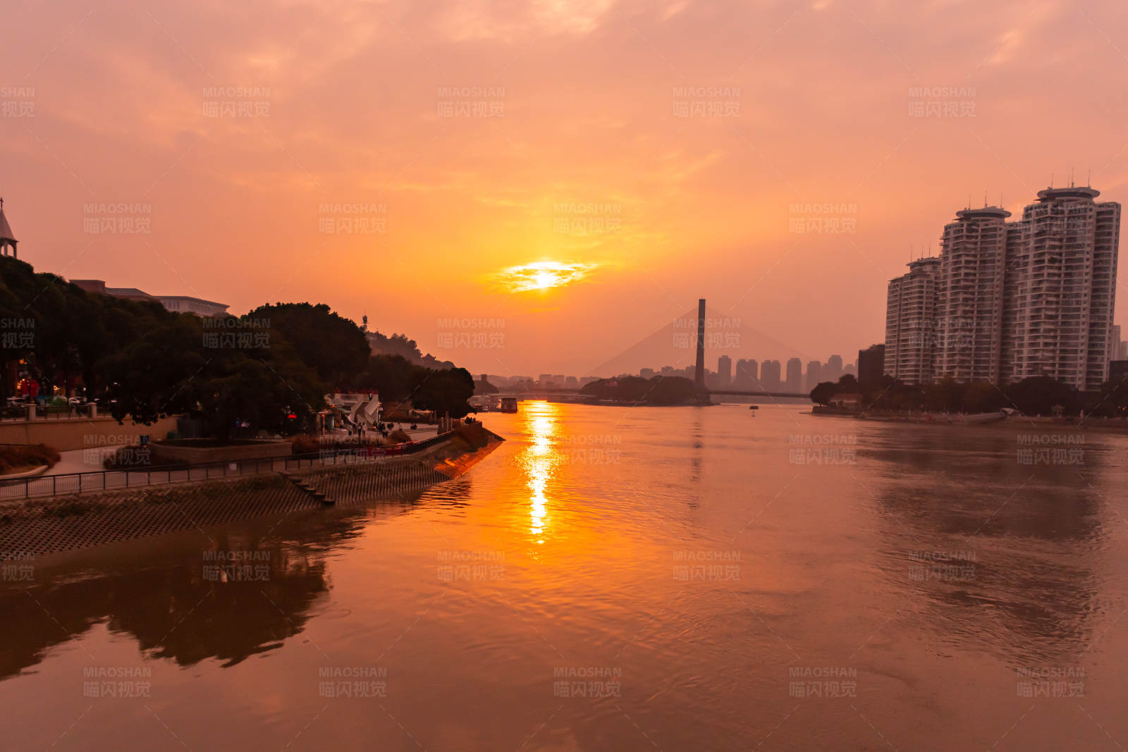夕阳映照下的城市河景图片
