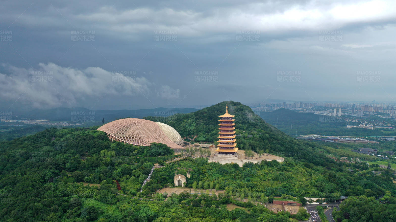 航拍雨后山巅古塔与现代建筑图片