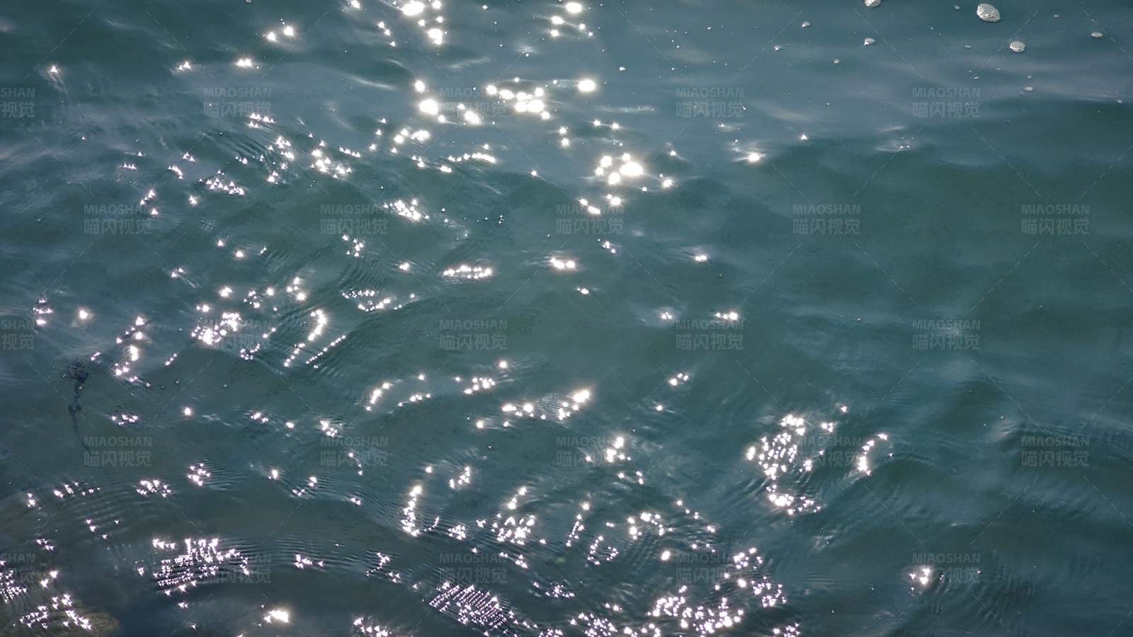 阳光洒在波光粼粼的水面上图片