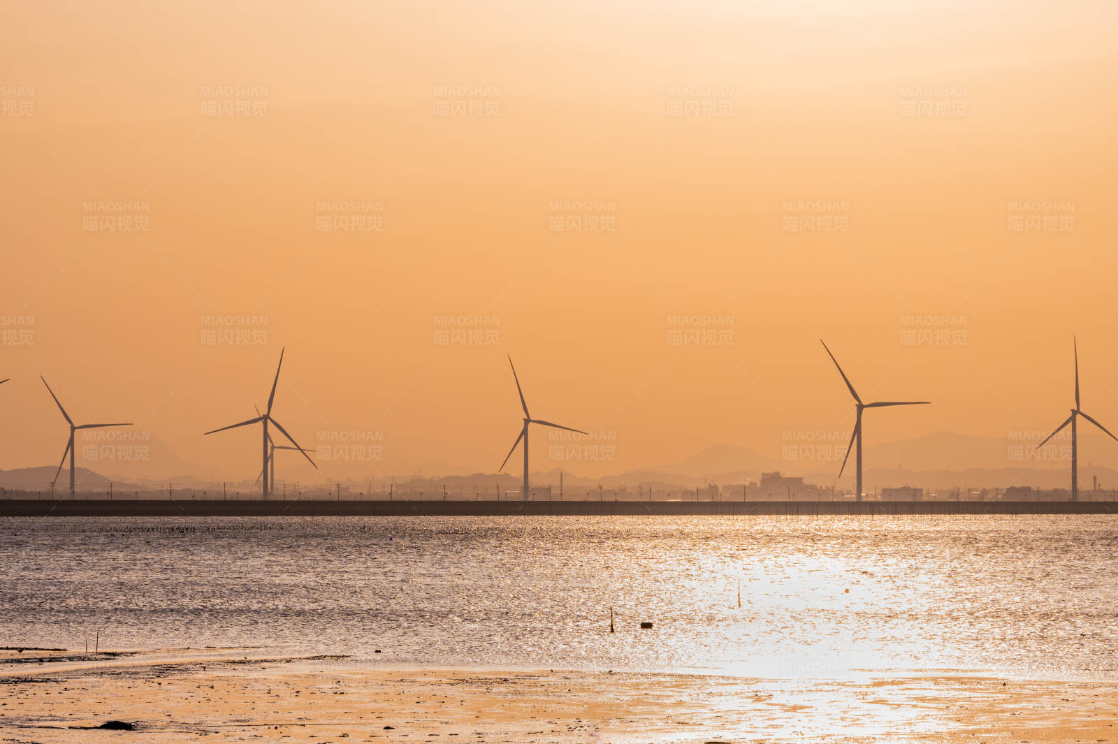 夕阳下的风车与海图片