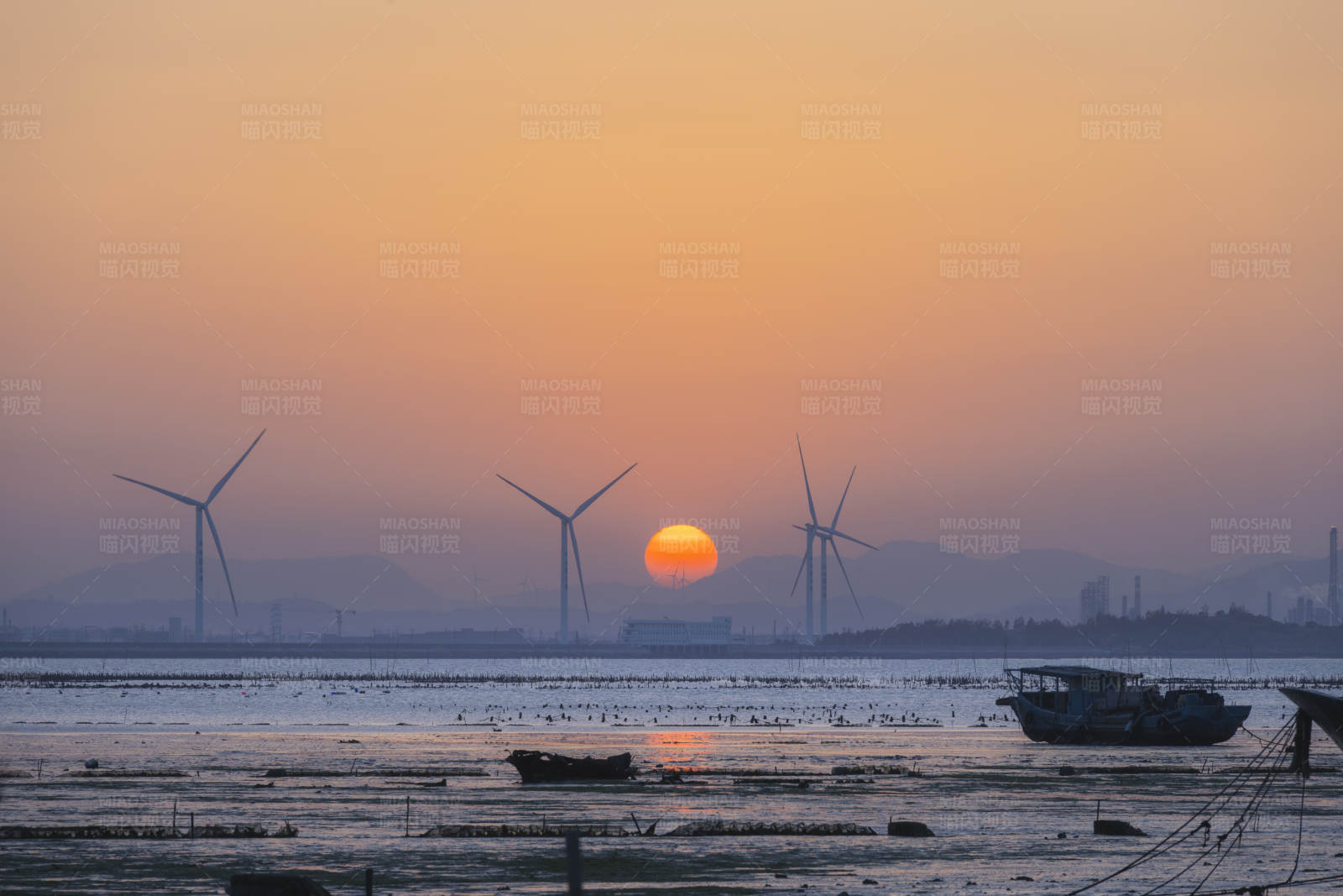 夕阳下的风车与渔船图片