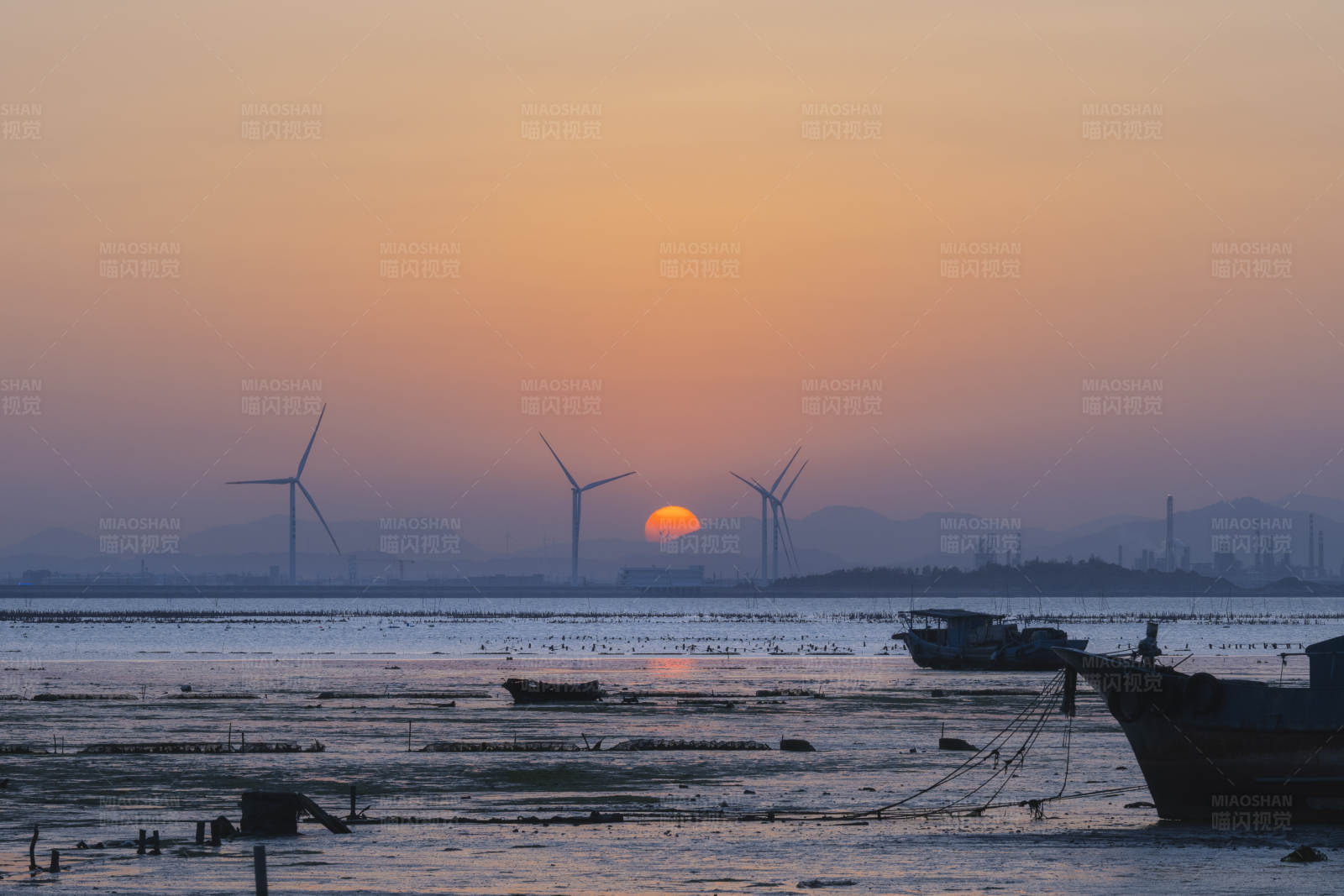 夕阳下的风车与渔船图片