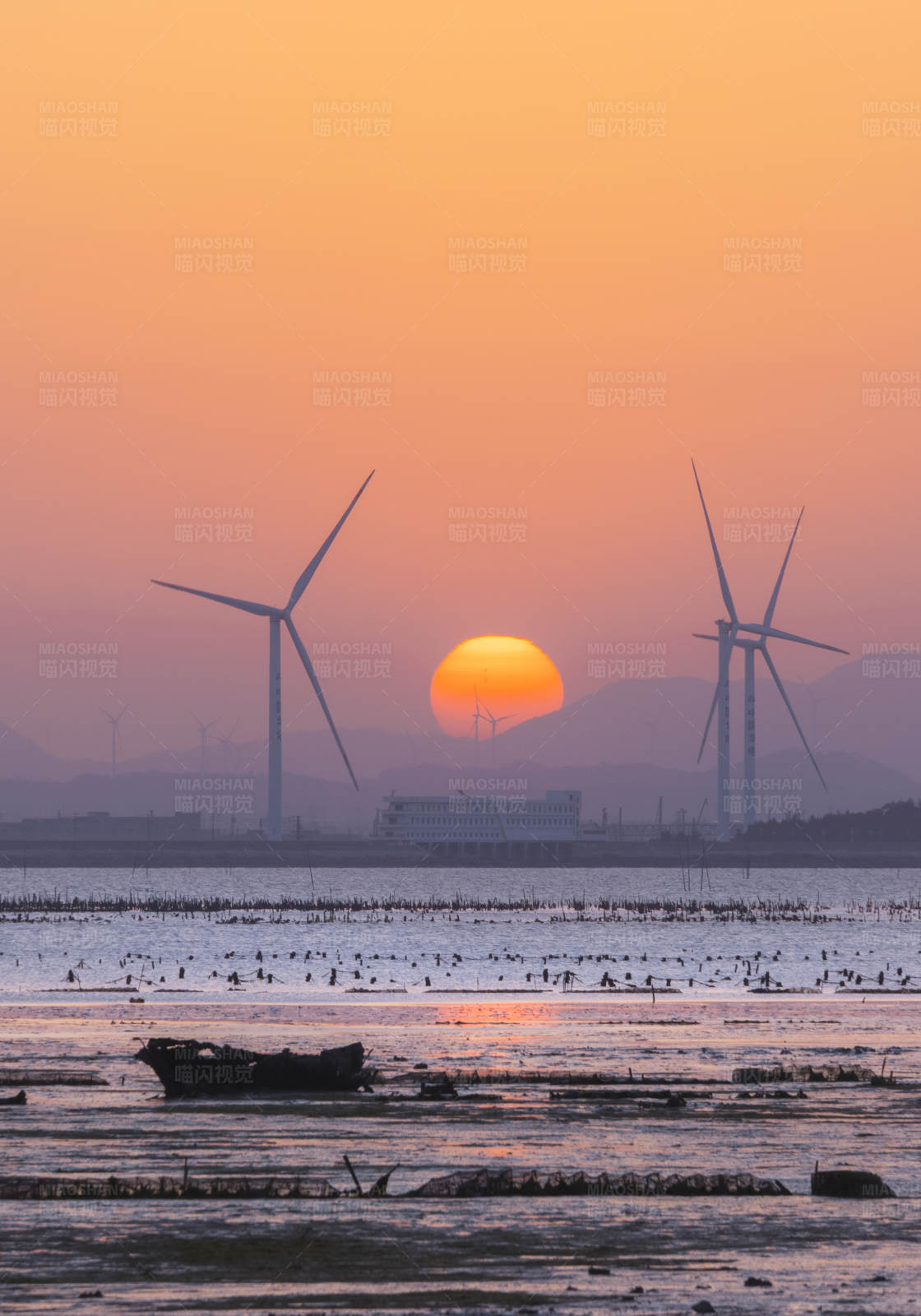 夕阳下的风车与海景图片