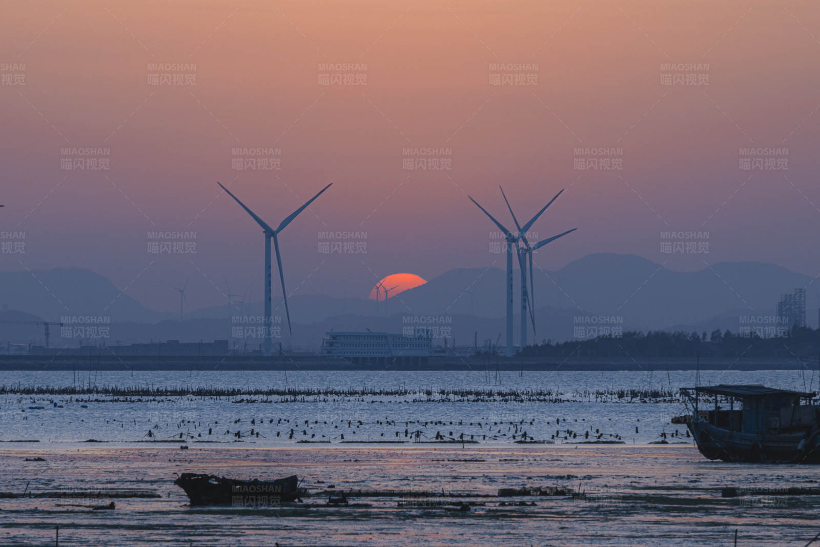 夕阳下的风车与渔船图片