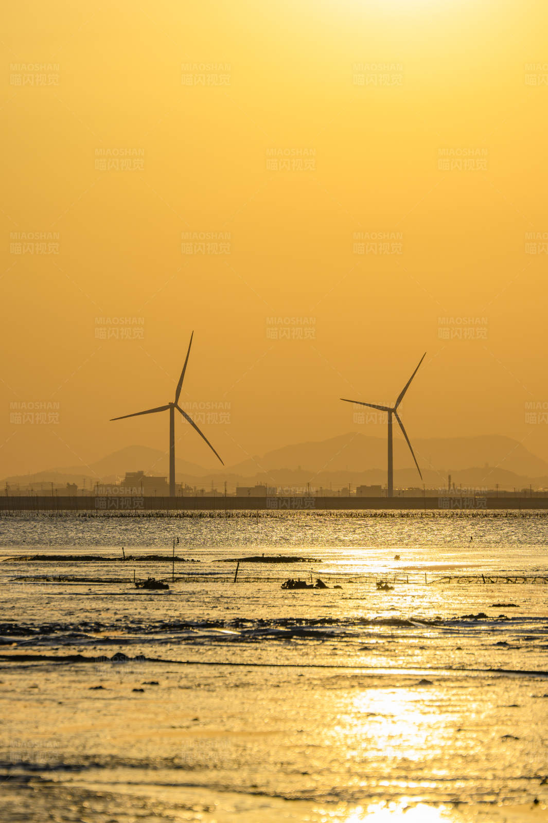 夕阳下的风车与海景图片