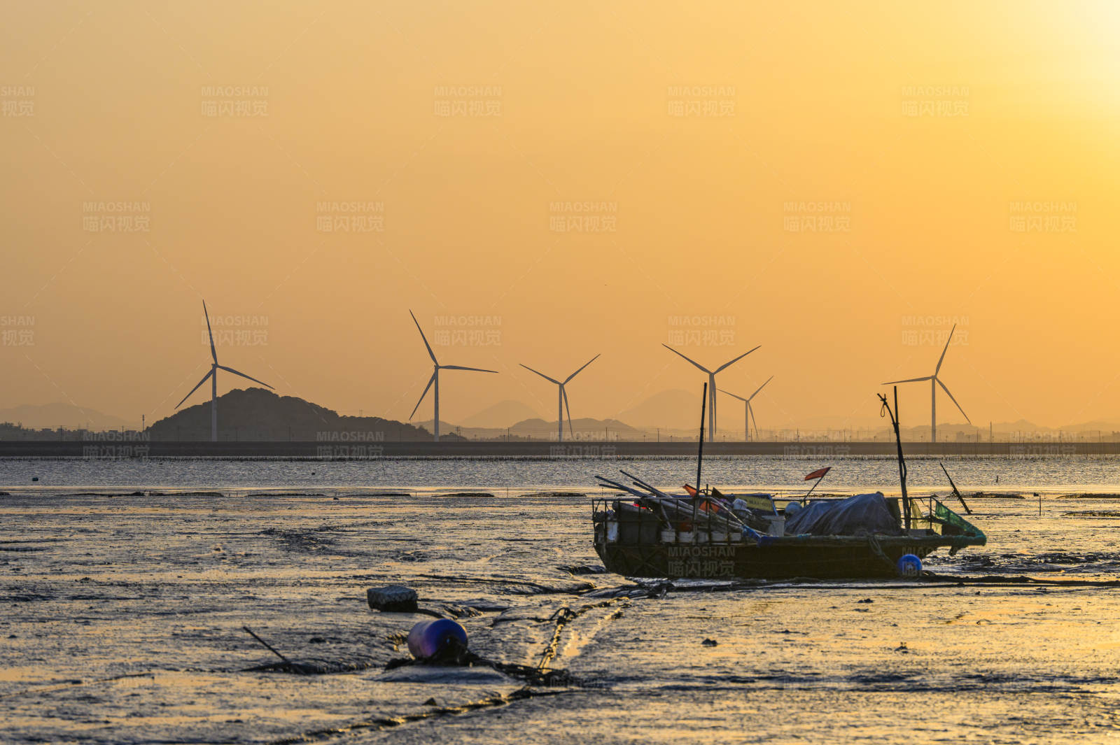 夕阳下的风车与渔船图片
