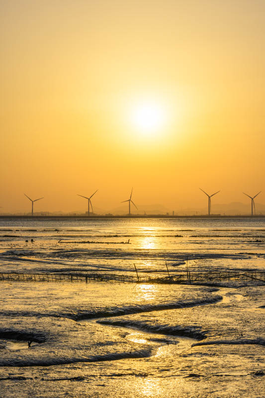 夕阳下的风车与海滩图片