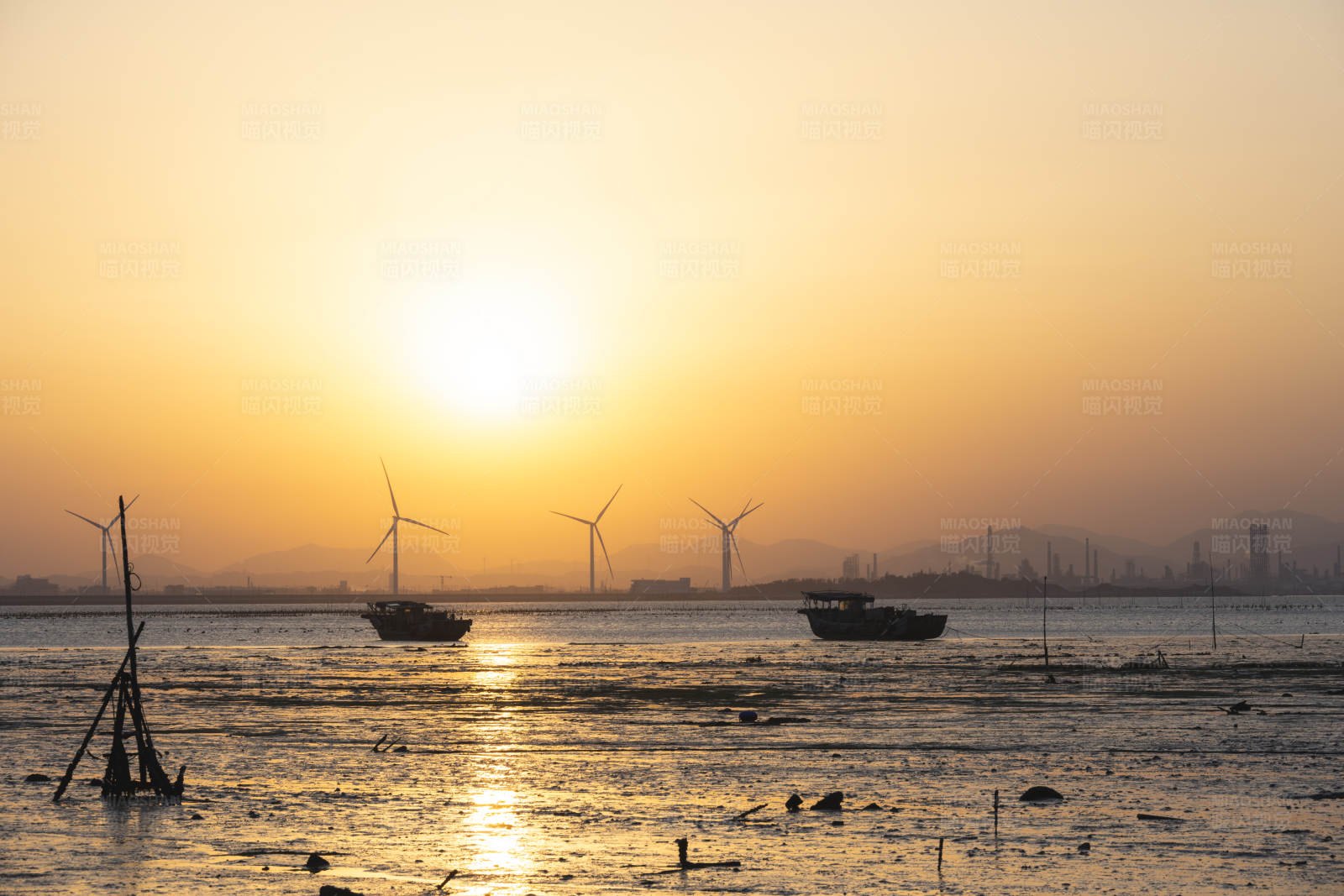 夕阳下的风车与渔船图片