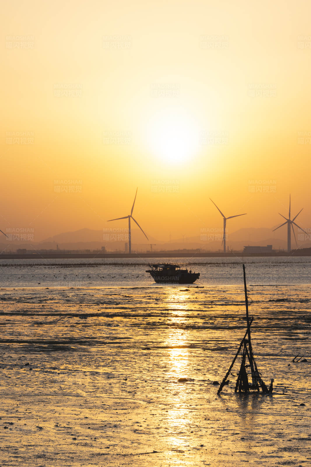 夕阳下的风车与渔船图片