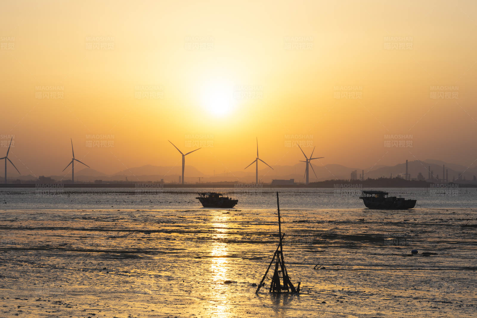 夕阳下的风车与渔船图片