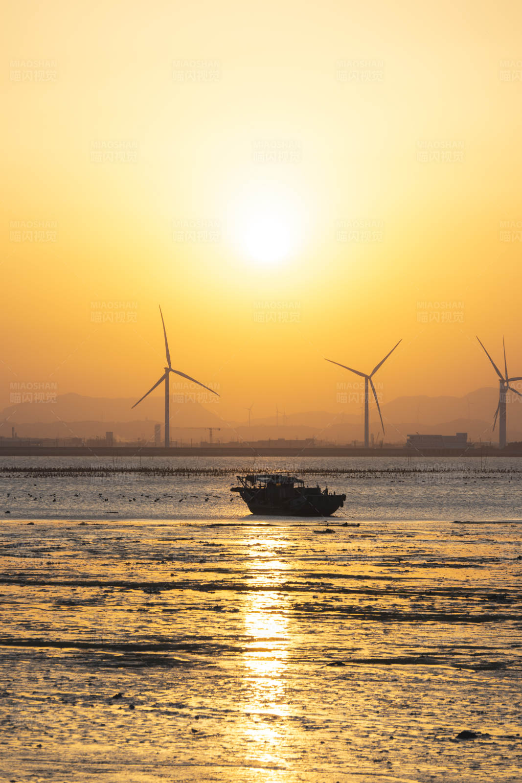夕阳下的风车与渔船图片