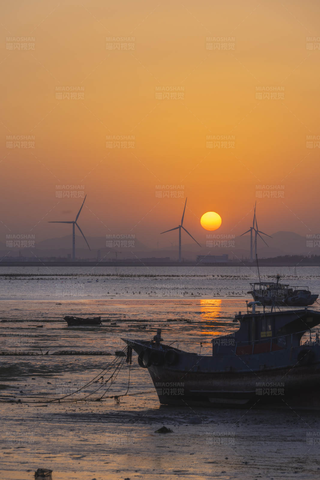 夕阳下的渔船与风车图片