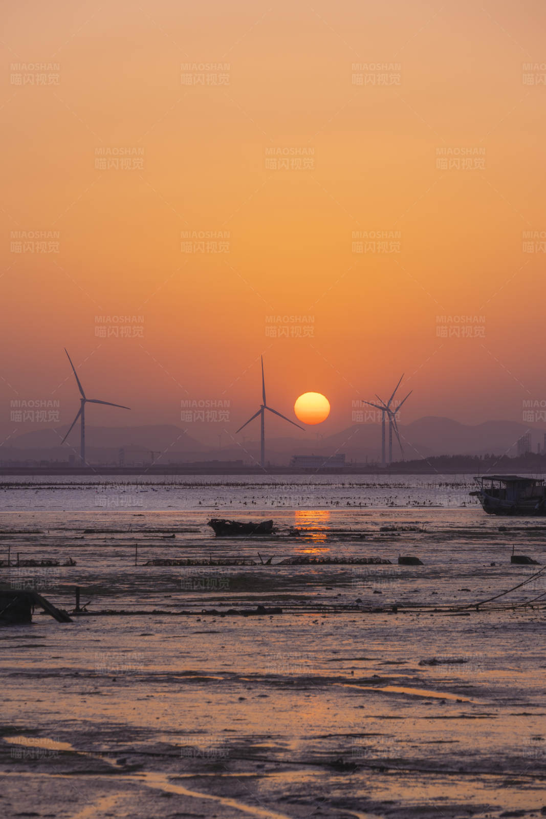 夕阳下的风车与海滩图片