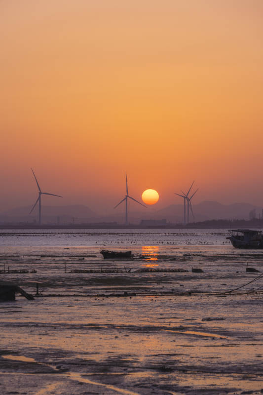 夕阳下的风车与海滩图片