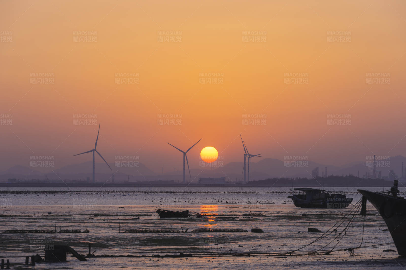 夕阳下的风车与渔船图片