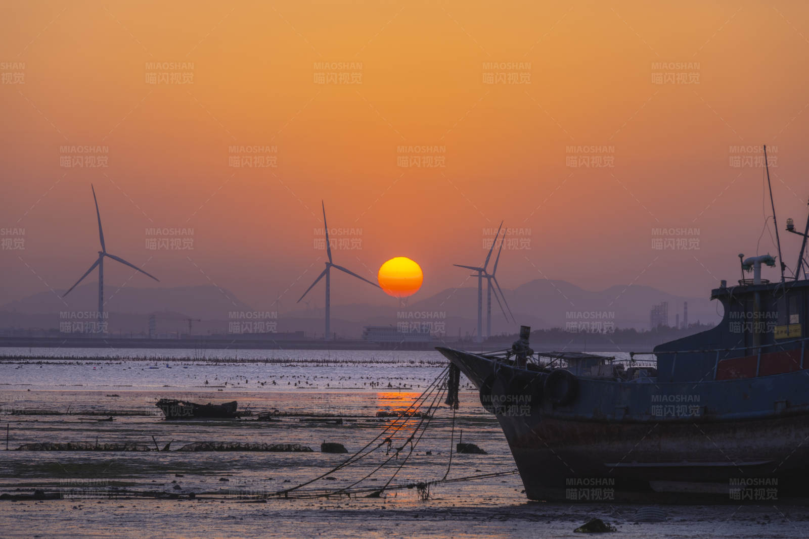 夕阳下的风车与渔船图片