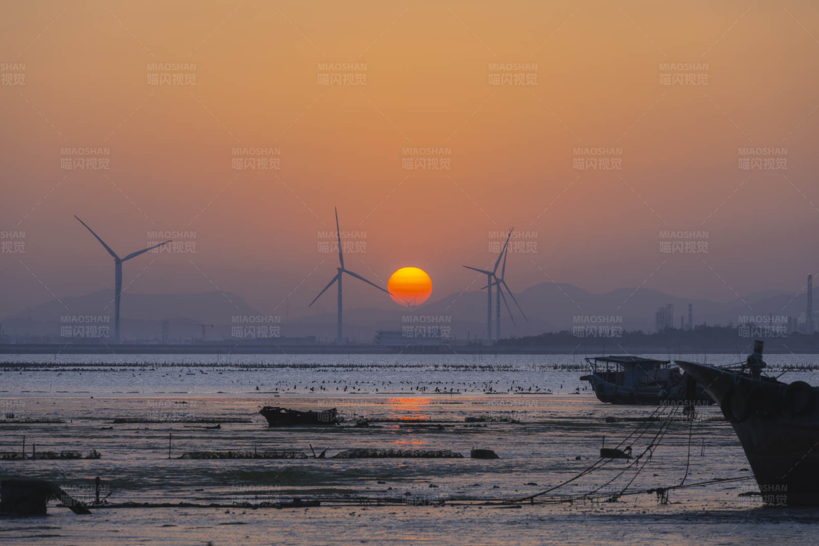 夕阳下的风车与渔船图片