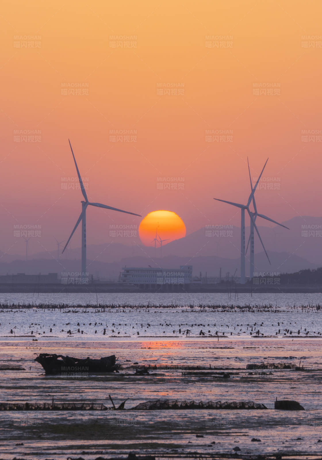 夕阳下的风车与海图片