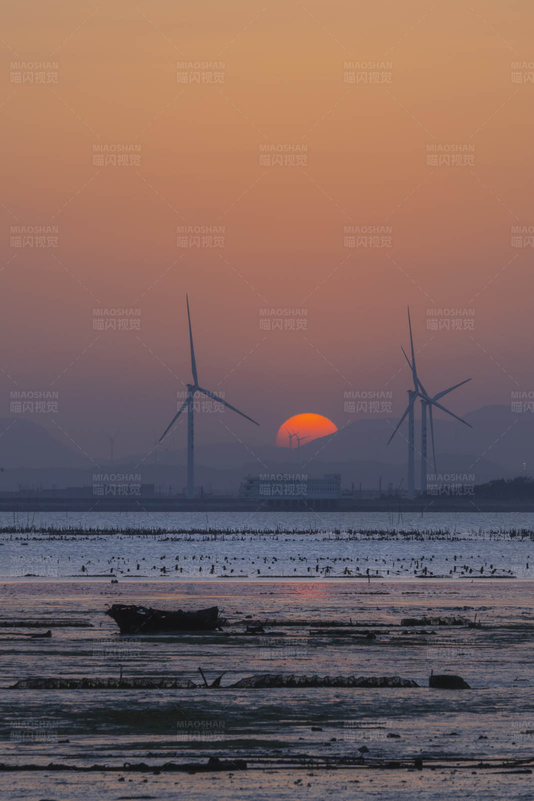夕阳下的风车与海图片