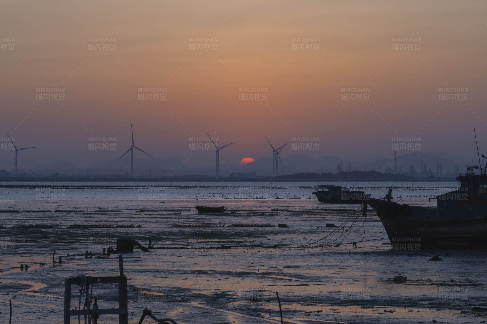 夕阳下的风车与渔船图片