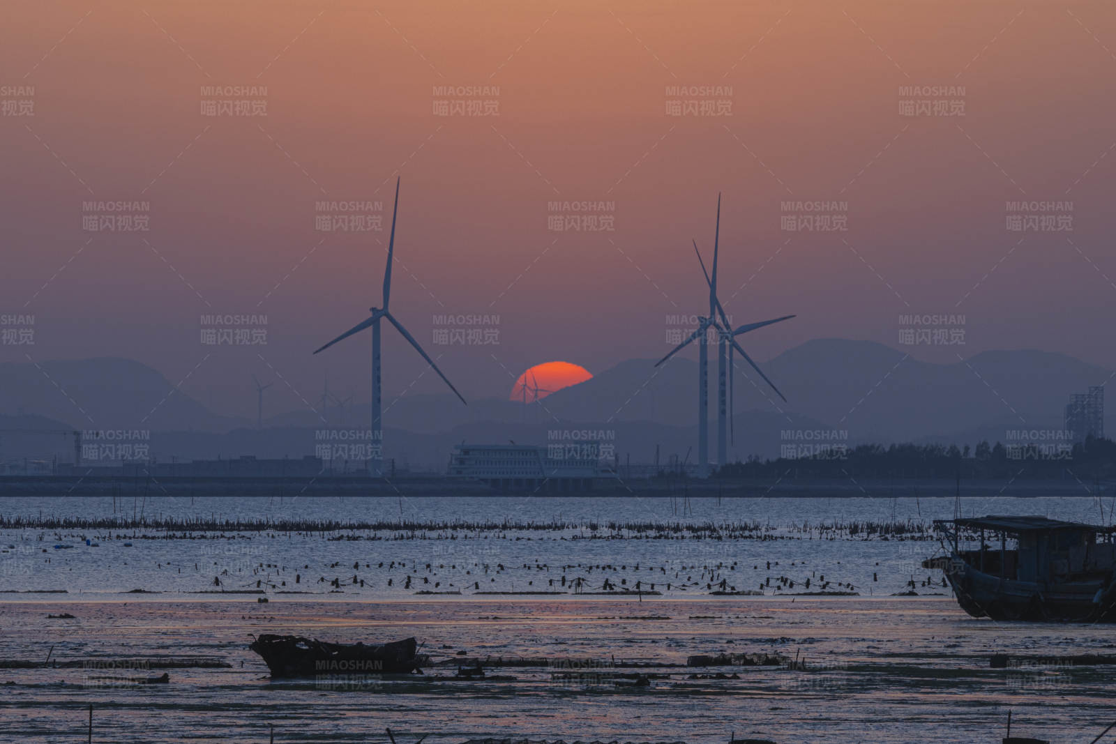 夕阳下的风车与渔船图片
