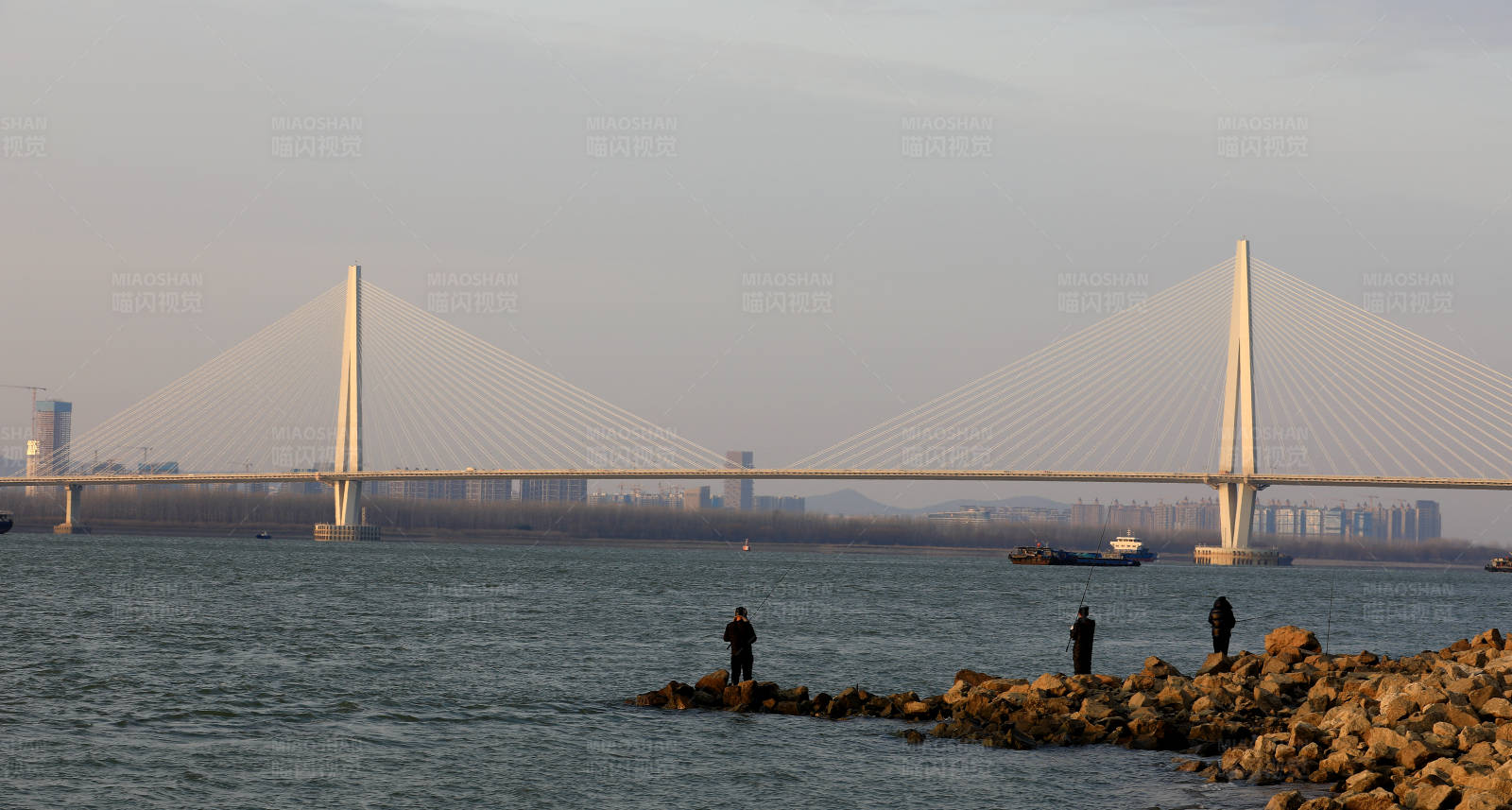 夕阳下的南京江心洲长江大桥和垂钓者图片