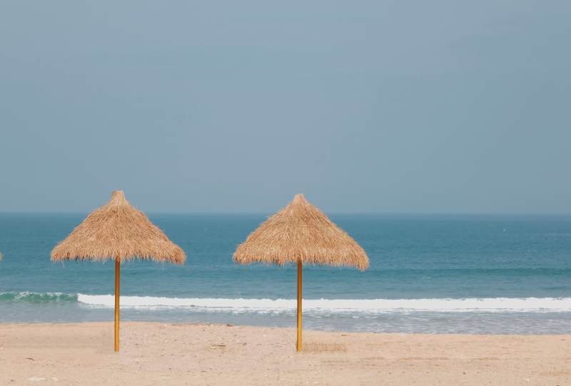 沙滩上的两把草伞图片