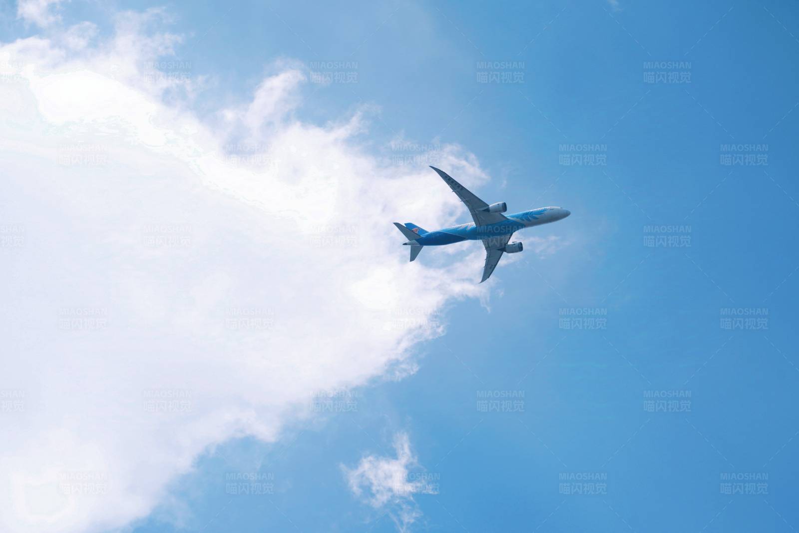 蓝天白云下飞行的南方航空波音787客机图片