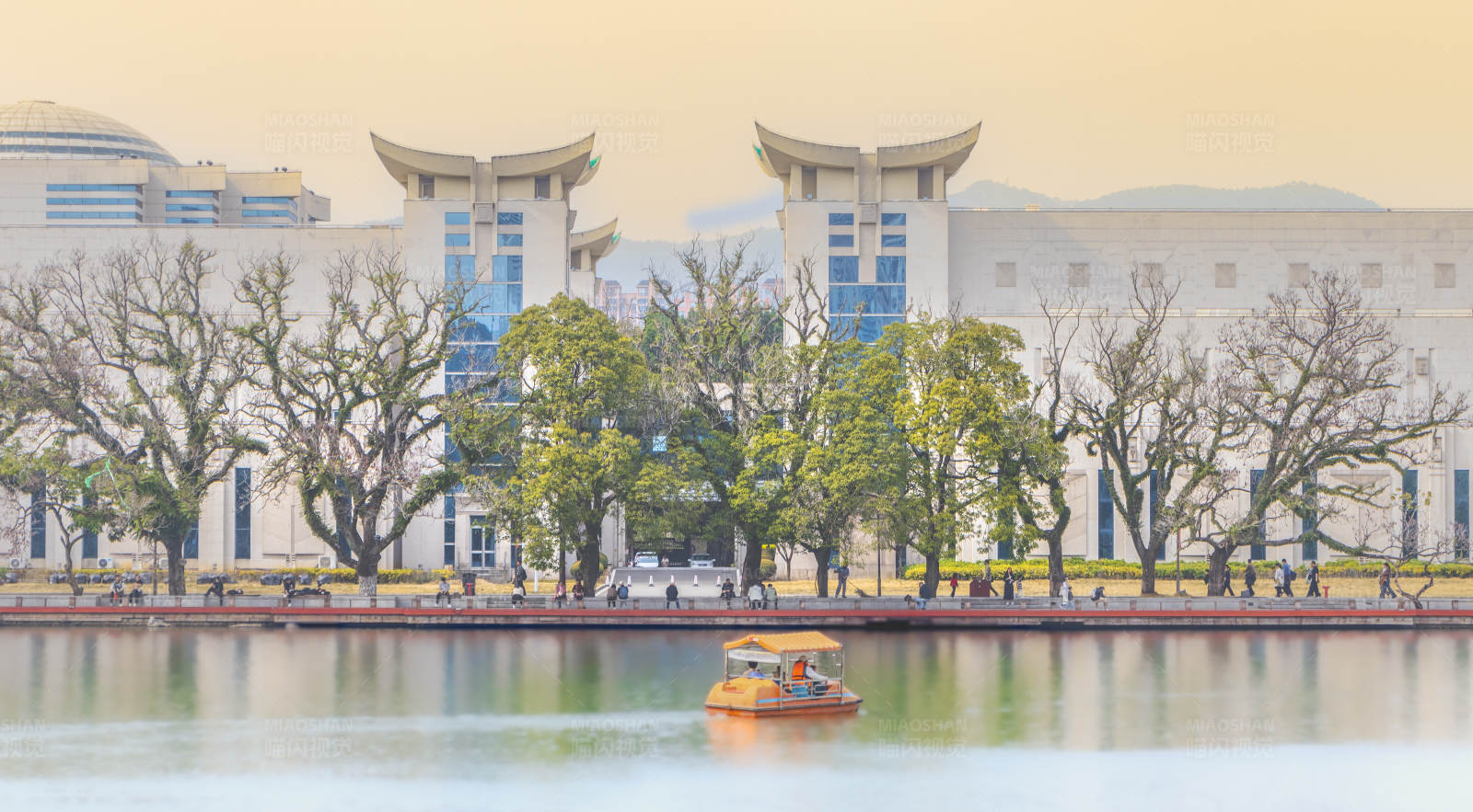 湖畔游船与现代建筑图片