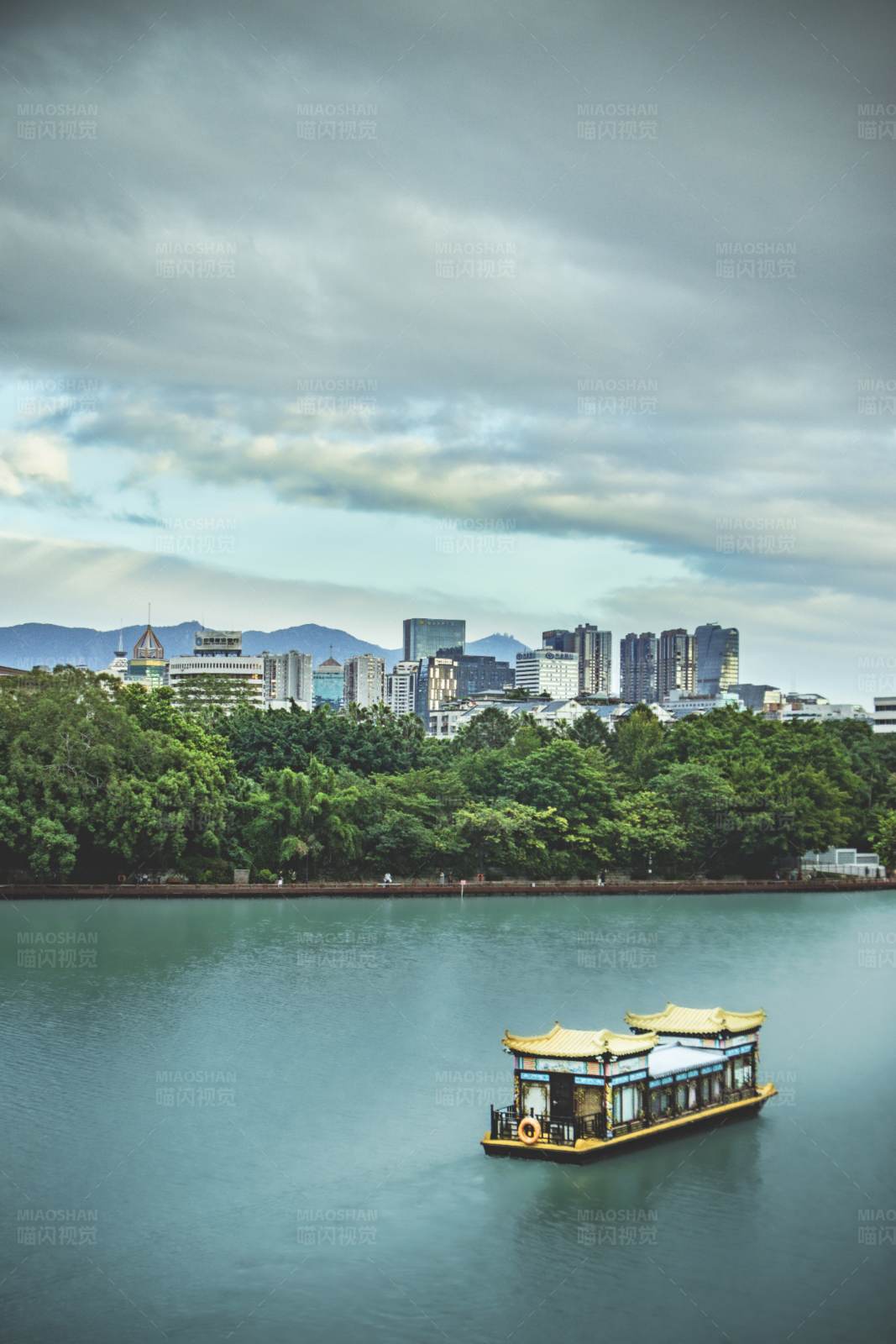 湖中游船与城市天际线图片