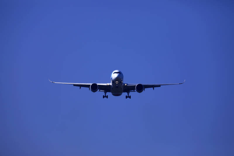 蓝天下降落的飞机正面特写图片