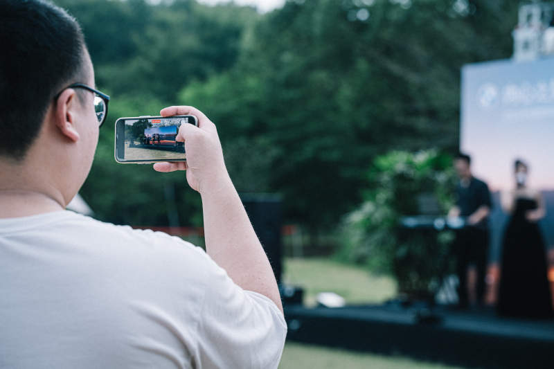 观众用手机拍摄舞台表演图片