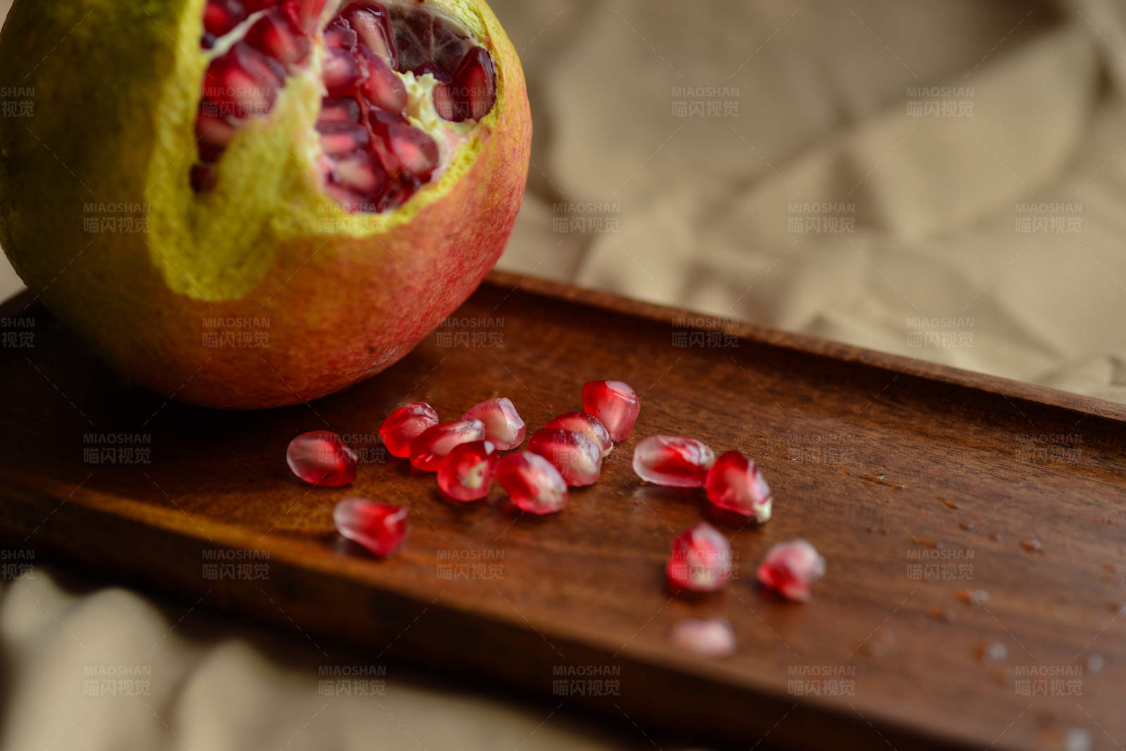 石榴籽散落在木板上图片