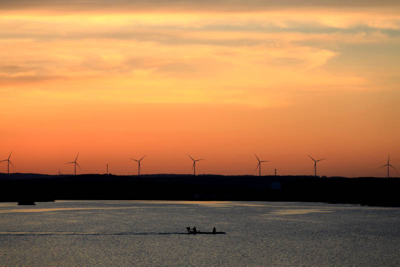 南京六合大泉水库夕阳下的风车和渔船图片