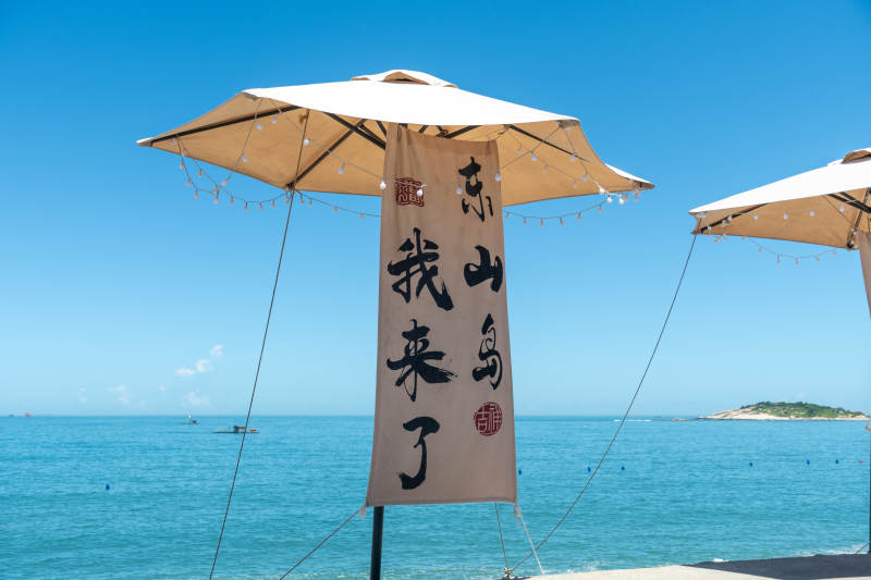 东山岛海边的旗帜和遮阳伞图片