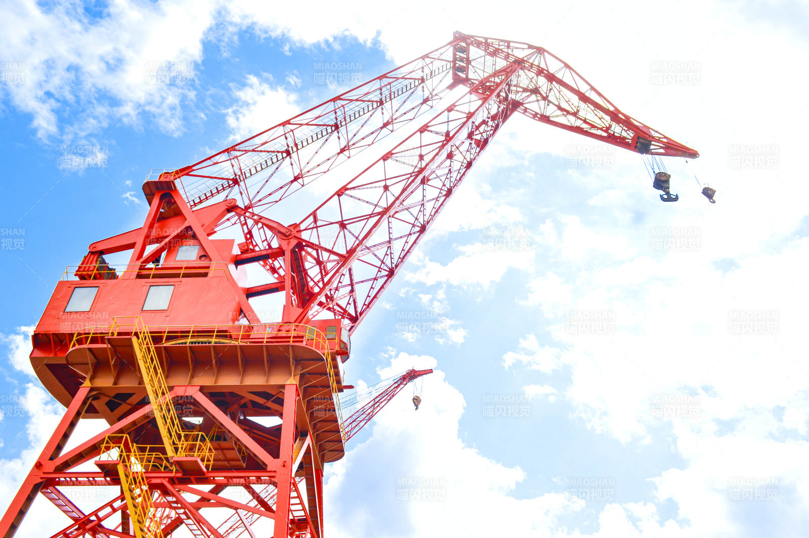 红色起重机在蓝天白云下图片