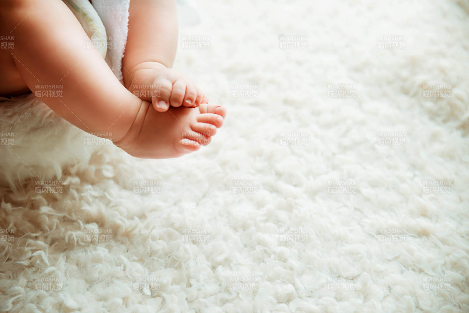 婴儿小脚踩在白色地毯上图片