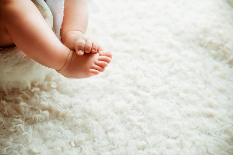 婴儿小脚踩在白色地毯上图片